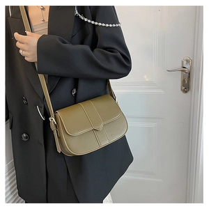 Retro olivgrüne Satteltasche mit minimalistischem Lederriemen am Modell präsentiert