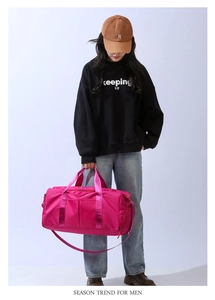 Detail of a large pink fitness bag with thick handles and adjustable shoulder strap