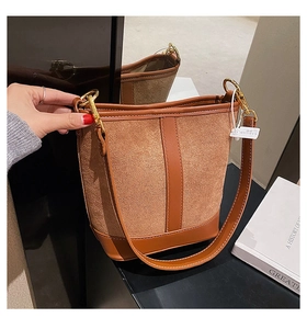 Detail of brown bucket bag showing contrast between suede texture and smooth leather finish