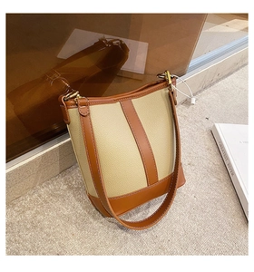 Detail of vintage bucket bag featuring beige pebble leather and brown trim stitching