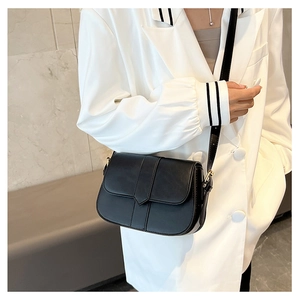 Seitenansicht der minimalistischen schwarzen matten Satteltasche zu weißem Blazer