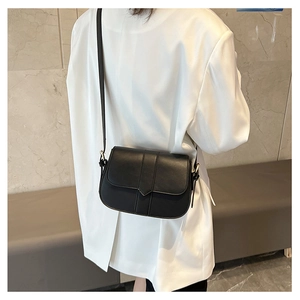 Detailansicht einer mattschwarzen Satteltasche, getragen von einem Modell in Weiß