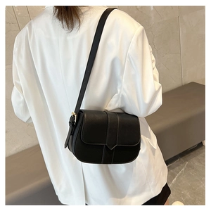 Detail einer schwarzen minimalistischen Satteltasche mit goldener Schnalle am Model