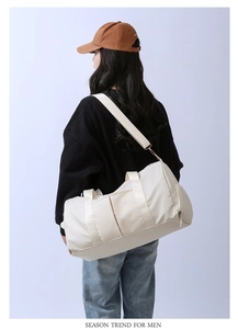Detailed view of off-white waterproof nylon gym bag with adjustable shoulder strap