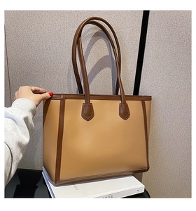 Detail shot of large contrast tote bag with premium leather texture and stitching