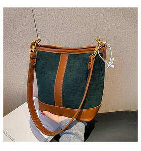 Detail of vintage patchwork bucket bag with green suede, brown leather and gold hardware