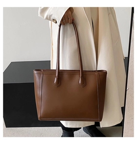 Detailed view of stitching and texture on minimalist dark brown tote bag for work