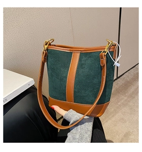 Detail of green and brown contrast stitching on vintage bucket bag with gold hardware