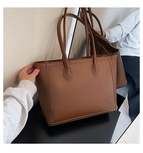 Detail shot of large brown tote bag with premium leather texture and durable stitching