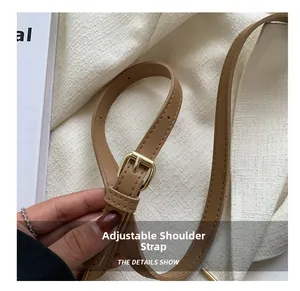 Detail of adjustable camel leather strap with gold buckle and fine stitching craftsmanship