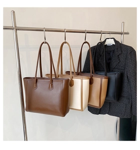 Hanging display of four commuter tote bags in dark brown, beige, tan, and black leather