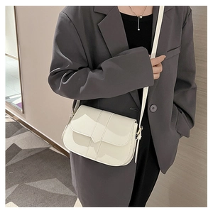 Detail einer minimalistischen cremeweißen PU-Leder Satteltasche mit Klappe und Riemendesign