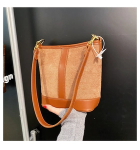 Detail view of retro brown拼接 bucket bag featuring matte suede and smooth leather textures