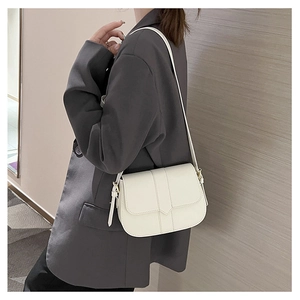 Model trägt eine weiße, minimalistische PU-Satteltasche mit schlichten vertikalen Nähten