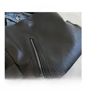 Détail macro du sac à main en cuir noir grainé avec fermeture éclair verticale métallique