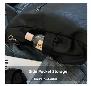 Détail de la poche latérale d'un sac en cuir noir avec fermeture éclair et anneau métal