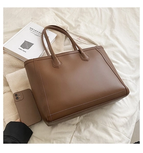 Brown leather tote bag showing large capacity for essentials in a lifestyle setting