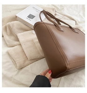 Detailed view of the brown leather tote bag showing smooth texture and fine stitching