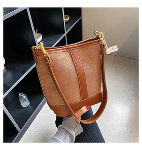 Detail of contrast stitch bucket bag with brown suede and leather splicing texture