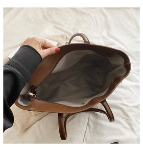 Top view of brown tote bag showing zipper closure and gray interior lining with pocket