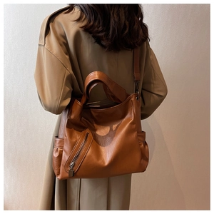 Vue détaillée du grand sac cabas en cuir souple marron avec poches latérales et zip chic