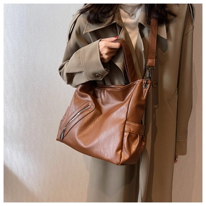 Détail d'un sac cabas en cuir PU marron avec bandoulière large sur un mannequin