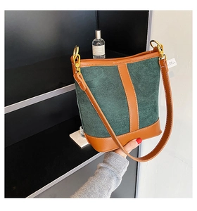 Detail of vintage color-block bucket bag with green suede and brown leather accents