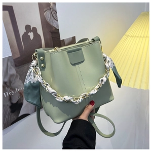 Light green bucket bag with a silk scarf gold chain handle and slim shoulder strap