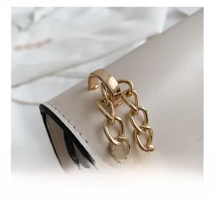 Detailed close-up of premium gold metal chain and hardware on the beige leather handbag