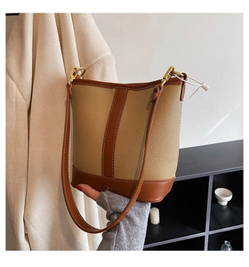 Detail of contrast stitching and bicolor leather texture on fashionable bucket bag