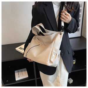 Vue détaillée du grand sac hobo crème avec texture grainée et large bandoulière