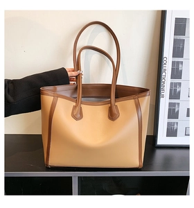 Close-up of brown and beige patchwork leather tote bag with fine stitching details