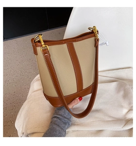 Detail of lychee pattern leather and white contrast stitching on the bucket bag