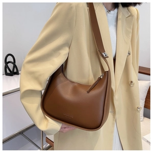 Detail of a brown PU leather half-moon bag with fashion bag NEW YORK engraving