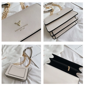 Detail view of cream-white accordion leather bag with gold deer logo and chain strap
