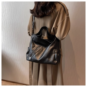 Détail du cabas en similicuir noir avec poches latérales porté par un mannequin