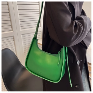 Close-up of green matte leather hobo bag with adjustable strap and fashion bag logo