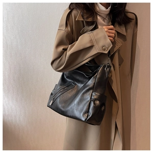 Détail du sac cabas en cuir PU noir avec poche zippée diagonale en métal et texture souple