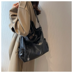 Vue latérale du grand sac cabas en cuir noir avec poches latérales et zips argentés