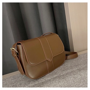 Detailansicht einer Retro-Satteltasche aus dunkelbraunem Leder mit goldener Metallschnalle