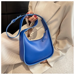 Detail of Klein blue crescent hobo bag with adjustable strap and fashion text