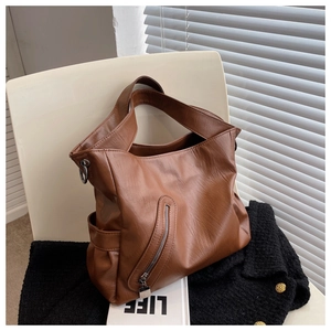 Détail du sac à bandoulière en cuir PU marron avec texture litchi et poche latérale