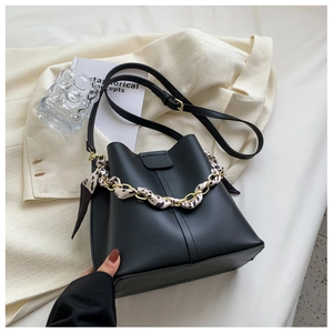 Close-up of black bucket bag featuring leopard print scarf wrapped gold chain handle