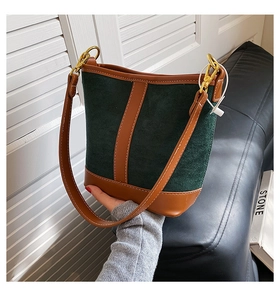 Detail of vintage contrast bucket bag featuring green suede and brown leather with gold hooks