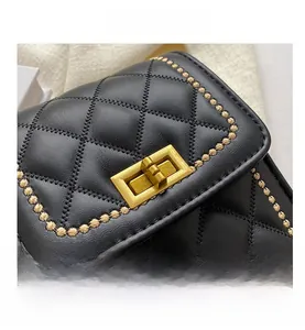 Close-up of black quilted leather bag with gold twist lock and bead embroidery details