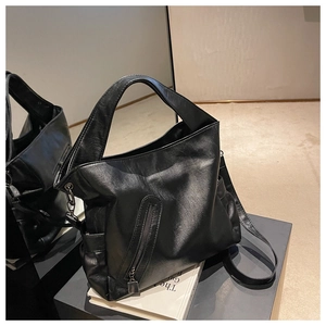 Détail du grand sac cabas noir en similicuir avec texture fine et poche zippée verticale