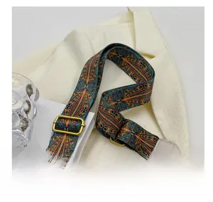 Gros plan sur la bandoulière tissée style ethnique avec motifs colorés et boucles dorées