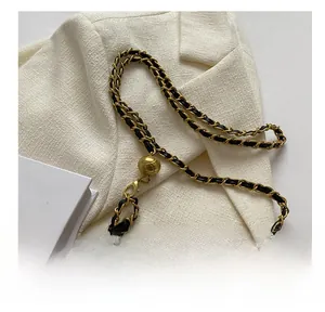 Detail of black quilted leather crossbody bag with adjustable gold metal ball chain strap