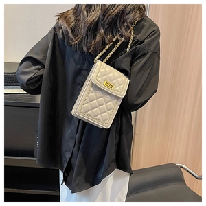 Detailed view of beige quilted mobile phone bag with golden beads and chain strap