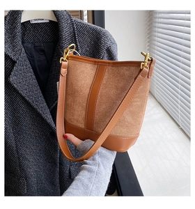 Detail of vintage brown bucket bag showing suede and smooth leather texture with gold buckle